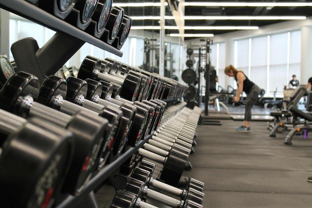Man lifting weights in a dark gym
